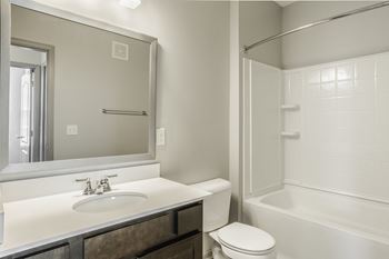 A white bathroom with a toilet, sink, and bathtub
